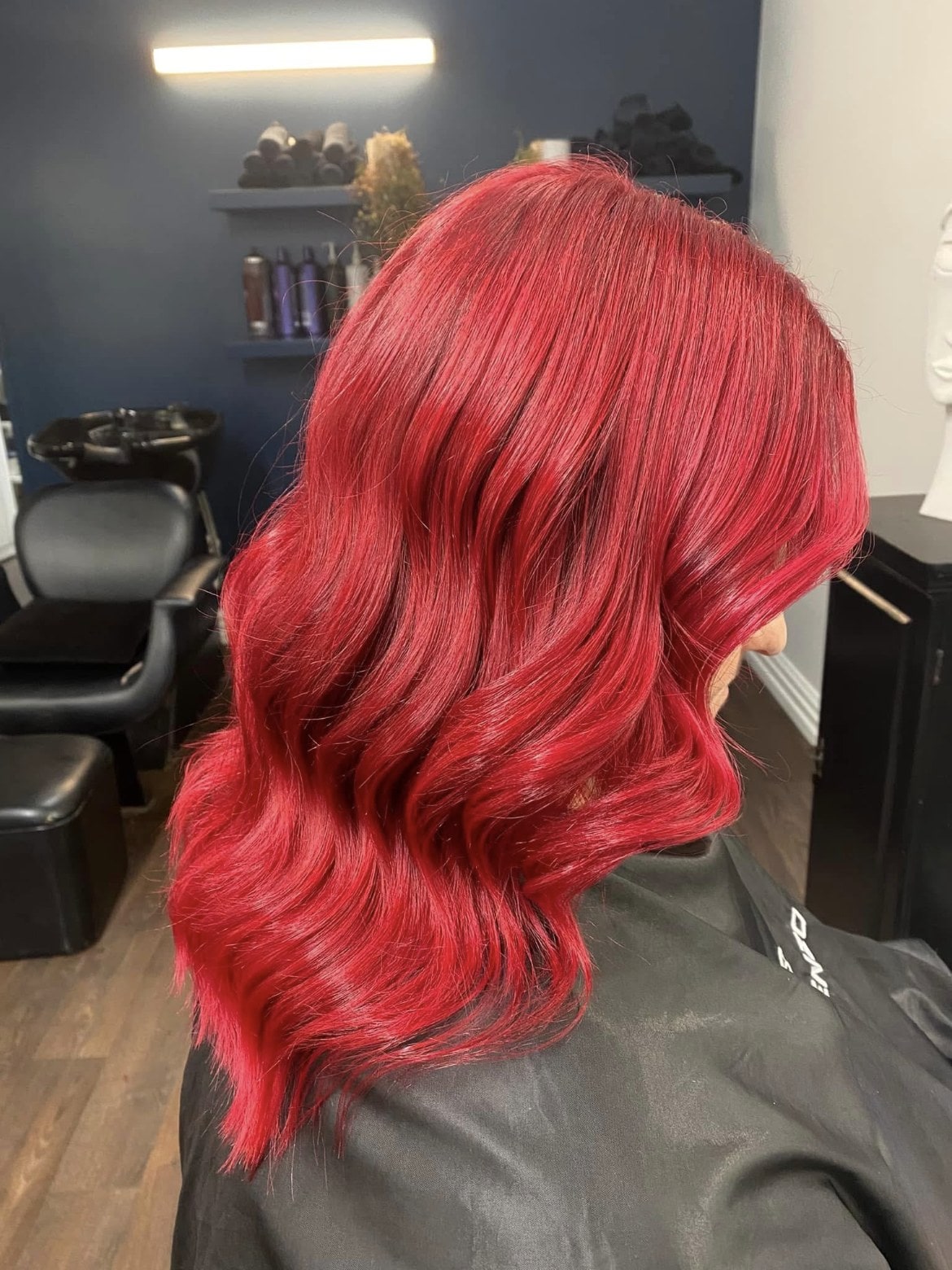 Vibrant red colour and waves by Raffles Hair Salon